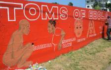 FILE: Liberian street artist Stephen Doe paints a mural to inform people about the symptoms of the deadly Ebola virus in Monrovia. Picture: AFP.