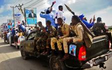 Security forces drive past campaign posters of the forthcoming Somali presidential elections in Mogadishu, Somalia. Picture: AFP.