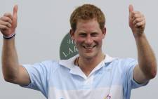 Britain's Prince Harry, celebrates the triumph of the Sentebale polo team, for which he played, over St. Regis in the Sentebale Royal Salute Polo Cup, on March 11, 2012 . Picture: AFP.
