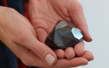 A picture taken on January 17, 2022 shows "The Enigma", a 555.55 carat black diamond, at Sotheby's in the Gulf emirate of Dubai. Picture: Giuseppe CACACE / AFP