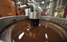 (FILES) This file photograph taken on 8 July 2013, shows hot chocolate before being moulded at the Barry Callebaut chocolate factory in Wieze, eastern Flanders. Swiss group Barry Callebaut, the world's largest cocoa and chocolate company, said on 30 June 2022, that it had halted chocolate production at its Wieze (Belgium) factory, billed as the world's largest, after salmonella was found in a batch on 26 June. Picture: GEORGES GOBET/AFP