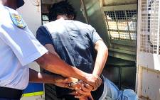 The suspect accused of raping a 6-week-old baby in Galeshewe, Northern Cape is put into a police van. Picture: Supplied.