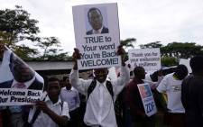 People gather outside Harare's airport to welcome former Zimbabwean vice-president Emmerson Mnangagwa on November 22, 2017 in Harare. Picture: AFP.