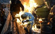 FILE: Protesters catch fire as they stand behind burning barricades during clashes with police on February 20, 2014 in Kiev. Picture: AFP. 
