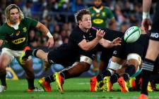 New Zealand's Brad Weber dives to pass the ball as South Africa's Faf de Klerk looks on during the Rugby Championship match on 2 October 2021. Picture: AFP