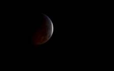 FILE: The moon turned dark before shining orange, brown and crimson in the shadow during the longest lunar eclipse of the 21st century on 27 July. Picture: @NASA/Twitter.
