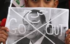 An Iraqi youth holds an image of Egyptian President Hosni Mubarak with a symbolic "X" drawn across his face. Picture: AFP