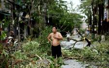 A man reacts while standing amidst uprooted trees in central Vietnam's Quang Ngai province on October 28, 2020, in the aftermath of Typhoon Molave. Picture: AFP