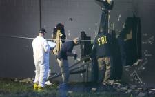FBI agents investigate near the damaged rear wall of the Pulse Nightclub where Omar Mateen allegedly killed at least 50 people on 12 June, 2016 in Orlando, Florida. Picture: AFP.