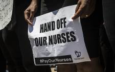 A woman holds a placard during a march by hundreds of nurses from across the country in central Pretoria for better pay and working conditions. Picture:Reinart Toerien/EWN