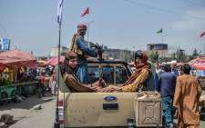 Taliban fighters on a pick-up truck move around a market area, flocked with local Afghan people at the Kote Sangi area of Kabul on August 17, 2021, after Taliban seized control of the capital following the collapse of the Afghan government. Picture: Hoshang Hashimi/AFP