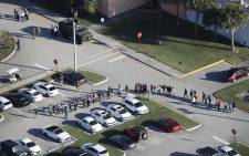FILE: People are brought out of the Marjory Stoneman Douglas High School after a shooting at the school that reportedly killed and injured multiple people on 14 February, 2018 in Parkland, Florida. Picture: AFP