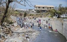 Residents bathe and clean laundry in a river 22 September 2017 in Canefield in the Caribbean island of Dominica, four days after the passage of Hurricane Maria. Picture: AFP.