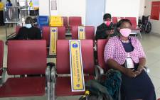 Kenyan passengers sit at the Jomo Kenyatta International Airport (JKIA), while observing social distancing as they wait to be checked in after the official launch on the resumption of local flights in Nairobi, on 15 July 2020. Picture: AFP