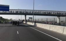 Police monitor protesters along the R300 near Kuils River on 22 July 2020. Picture: @SAPoliceService/Twitter
