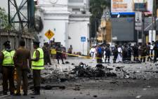 Sri Lankan security personnel inspect the debris of a car after it explodes when police tried to defuse a bomb near St Anthony's Shrine in Colombo on 22 April 2019, a day after the series of bomb blasts targeting churches and luxury hotels in Sri Lanka. Picture: AFP