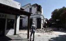 A pedestrian looks at the ruins of a bar on the island of Kos on 21 July 2017, where two patrons are said to have died following a 6.5 magnitude earthquake which struck the region. Picture: AFP.