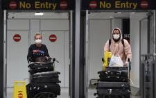  In this file photo taken on 8 June 2020 passengers wearing PPE (personal protective equipment), including a face mask as a precautionary measure against COVID-19, arrive at Terminal 1 of Manchester Airport in north west England. Picture: AFP