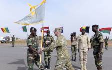 Senegals Army General Amadou Kane (L) receives the 2016 Flintlock flag from US Army General Donald Bolduc during the inauguration of a military base in Thies, 70 km from Dakar, on 8 February 2016 on the second day of a three-week joint military exercise between African, US and European troops, known as Flintlock.  Picture: Seyllou/AFP.