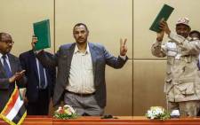(L to R) Ethiopian mediator Mahmoud Drir, protest leader Ahmad Rabie, and General Mohamed Hamdan Daglo, Sudan's deputy head of the Transitional Military Council, celebrate after signing the constitutional declaration, at a ceremony attended by African Union and Ethiopian mediators in the capital Khartoum on 4 August 2019. Picture: AFP