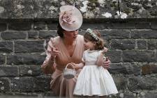 FILE: Britain's Catherine, Duchess of Cambridge, speaks to her daughter Princess Charlotte at the wedding of her sister Pippa Middleton on 20 May 2017. Picture: AFP.
