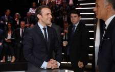 En Marche ! Movement Emmanuel Macron speaks with journalist Gilles Bouleau before taking part in a debate between five candidates for the French presidential election, organised by French private TV channel TF1, on 20 March, 2017 in Aubervilliers, outside Paris. Picture: AFP.