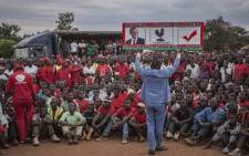A supporter of Lazarus Chakwera, leader of the Malawi Congress Party (MCP), the main Malawi opposition party, holds a sign during a campaign rally at Chowo Primary school in Lilongwe on 12 May 2019, ahead of Malawi's general election. Picture: AFP.