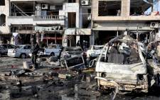 A handout picture made available by Syrian Arab news agency SANA shows Syrian policemen and citizens inspect the site of two terrorist bomb attacks at a security checkpoint in the residential neighbourhood of Zahra, Homs, Syria, 26 January 2016. Picture: EPA/SANA handout.