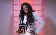 Internationally accredited money coach and author Busi Selesho seen with her book 'Money and Black People' Picture: Ihsaan Haffejee/EWN