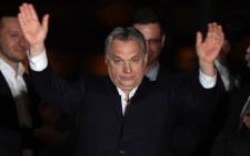 Hungarian Prime Minister Viktor Orban celebrates on podium on the bank of the Danube River after winning the parliamentary election with members of his FIDESZ party on 8 April, 2018 in Budapest. Picture: AFP.