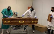 Undertakers at the People's Choice Funerals and Mortuary prepare a coffin for burial. Picture: Kaylynn Palm/EWN