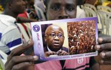 FILE: A supporter of Ivory Coast's former president Laurent Gbagbo holds a flyer picturing Gbagbo and reading in French "April 11 Solidarity with Laurent Gbagbo" during a demonstration on April 11, 2015 in Abidjan. Picture: AFP