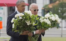 US President Barack Obama and Vice President Joe Biden place flowers for the victims of the mass shooting at a gay nightclub Sunday at a memorial at the Dr. Phillips Center for the Performing Arts in Orlando, Florida, 16 June, 2016. Picture: AFP.