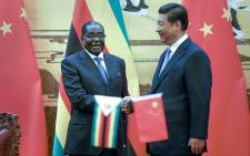 Zimbabwean President Robert Mugabe (L) and his Chinese counterpart Xi Jinping shake hands during a signing ceremony at the Great Hall of the People in Beijing on August 25, 2014. China's President Xi hailed Mugabe -- a pariah in the West -- as a renowned African liberation leader and an "old friend" of the Chinese people. Picture: AFP.