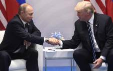 FILE: US President Donald Trump and Russia's President Vladimir Putin shake hands during a meeting on the sidelines of the G20 Summit in Hamburg, Germany on 7 July 2017. Picture: AFP.