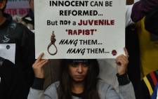 FILE: An Indian protester holds a placard during a demonstration against the release of a juvenile rapist in New Delhi on 21 December 2015. India's Supreme Court on 21 December 2015 rejected an appeal against the release of the youngest convict in an infamous fatal gang-rape, sparking fury from the victim's parents who said the ruling was a betrayal of women. AFP.