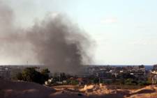 Smoke billows from buildings after the air force from the pro-government forces loyal to Libya's Government of National Unity (GNA) fired rockets targeting Islamic State (IS) group positions in Sirte. Picture: AFP.