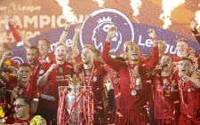 Liverpool captain Jordan Henderson (C), defender Virgil van Dijk (3R), midfielder James Milner (2R) and defender Andrew Robertson (R) pose with the Premier League trophy during the presentation following the English Premier League football match between Liverpool and Chelsea at Anfield in Liverpool, north west England on 22 July 2020. Picture: AFP