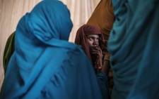 A woman looks on as she is surrounded by other women at the compound of the Agda Hotel, Ethiopia on 14 February 2022. 
