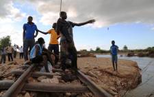 Boys fish from a railway track which was swept away by flash floods from the Ntamoyo River in Bangula on 23 January, 2015. Picture: Aletta Gardner/EWN.