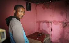 A Khayelitsha resident stands in his water-damaged home on 24 July 2015 after heavy rains caused misery for informal settlement residents. Picture: Aletta Gardner/EWN