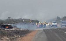 FILE: Firefighters attend to the blaze along Red Hill Road. Picture: Kevin Brandt/EWN.