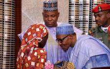 Nigerian President Mohammadu Buhari speaks with Chibok schoolgirl Amina Ali carrying her four-month-old baby as Borno state governor Kashim Shettima (C) looks on at her arrival at the presidency in Abuja, on 19 May 2016. Picture: AFP.
