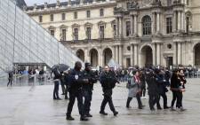 Police officers patrol in front of the Louvre Pyramid in Paris on 4 February, 2017 a day after a machete-wielding attacker lunged at four French soldiers while shouting “Allahu Akbar” in a public area that leads to one of the Louvre Museum’s entrances. Picture: AFP.