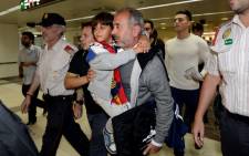 Osama Abdul Mohsen (centre right), the Syrian refugee who made world headlines when a Hungarian journalist tripped him over as he fled, with his son Zaid in the corridors of Sants train station in Barcelona prior to leaving for Madrid on 16 September 2015. Picture: AFP.