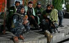 Taliban fighters sit along the roadside near Sardar Mohammad Dawood Khan military hospital in Kabul on 2 November 2021 after at least 19 people were killed and 50 others wounded in an attack. Picture: AFP