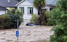 This handout picture taken on 17 August 2022 by local media outlet Andrew App and released on 18 August shows a flood-inundated car and homes from the overflowing Maitai River in central Nelson on New Zealand's South Island. Picture: Sara HOLLYMAN / ANDREW APP / AFP