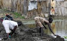 People try to build mud dams at the inundated Dibba Busin camp for South Sudanese refugees in Sudan's White Nile state, after floods destroyed their shelters, on September 15, 2021. Picture: Ashraf Shazly / AFP