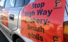Cosatu members prepare for the drive-slow protest by attaching anti-e-toll banners onto their cars. Picture: Christa van der Walt/EWN