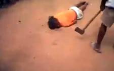 A screengrab from apparent cellphone footage which has gone viral showing a woman being kicked in the face, stomped on and beaten with an axe. Picture: Facebook.